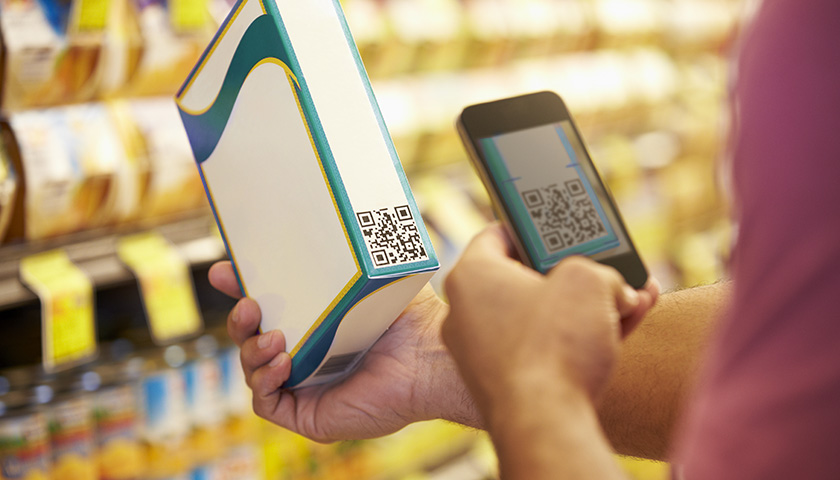 Ein Kunde überprüft den Barcode einer Verpackung um Food Fraud auszuschließen